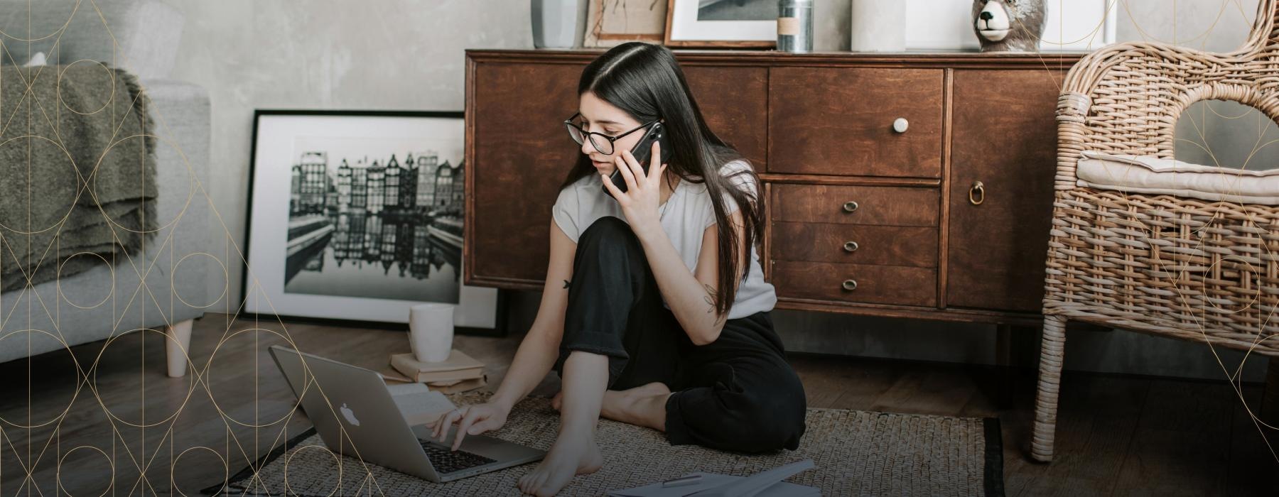 a woman sitting on the floor with a laptop